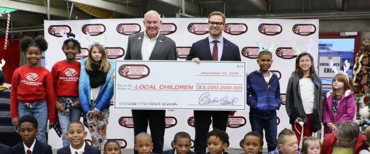 Speedway Children's Charities Vice Chairman and Charlotte Chapter President Marcus Smith, fourth from right on the top row, joins Speedway Children's Charities Executive Director Maj. Gen. Chuck Swannack, fourth from left on the top row, along with grant recipients at a special presentation on Wednesday at Charlotte Motor Speedway.